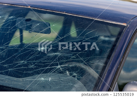 Broken windshield on a car. Damaged glass on a car. Broken windshield on a car. Damaged glass on a car. 125535019