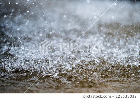 Water splashes on a blurred background. Drops of water fly in the air. Selective focus Water splashes on a blurred background. Drops of water fly in the air. Selective focus 125535032