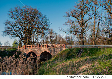 Old stone bridge over the river in the park in spring. 125535055