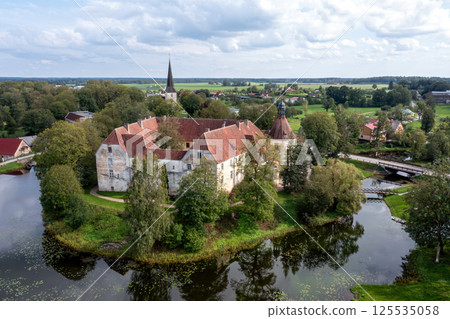 Jaunpils castle was built in 1301. as Livonia Order fortress. Latvia, aerial drone view Jaunpils castle was built in 1301. as Livonia Order fortress. Latvia, aerial drone view 125535058