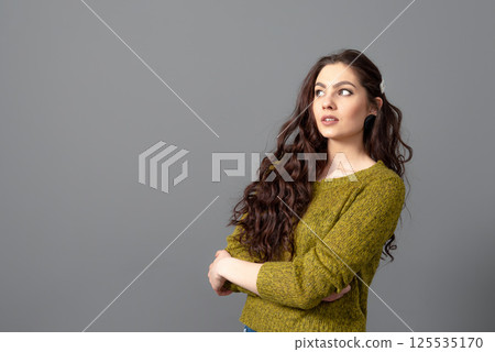 portrait of beautiful sensual woman with long curly hair against gray background 125535170