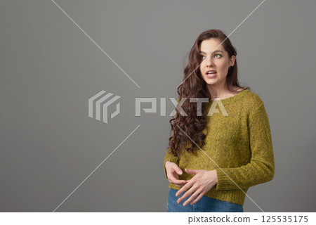 portrait of beautiful sensual woman with long curly hair against gray background portrait of beautiful sensual woman with long curly hair against gray background 125535175