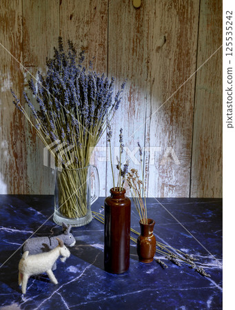 Felt toys of goats and donkeys, stems with lavender flowers in clay vases Felt toys of goats and donkeys, stems with lavender flowers in clay vases 125535242
