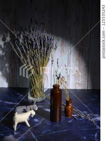 Felt toys of goats and donkeys, stems with lavender flowers in clay vases Felt toys of goats and donkeys, stems with lavender flowers in clay vases 125535243