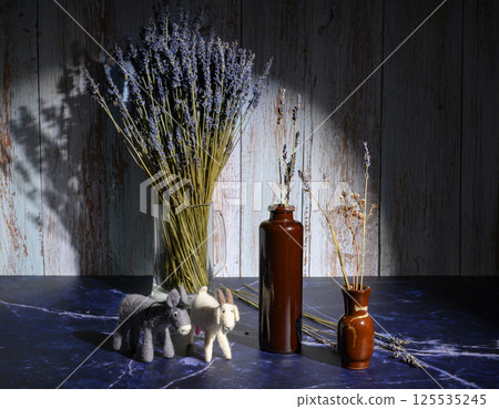 Felt toys of goats and donkeys, stems with lavender flowers in clay vases Felt toys of goats and donkeys, stems with lavender flowers in clay vases 125535245