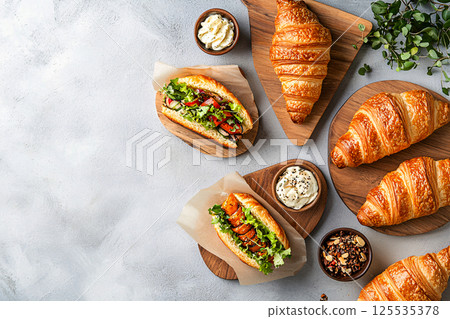 Freshly filled handcrafted croissant sandwiches, styled elegantly for a modern cafe menu aesthetic 125535378