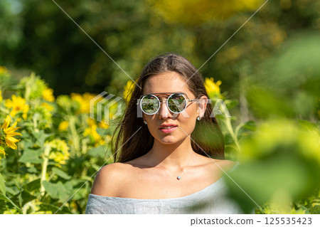 pretty sensual young brunette in sunglasses in a field of blooming sunflowers, young woman portrait pretty sensual young brunette in sunglasses in a field of blooming sunflowers, young woman portrait 125535423