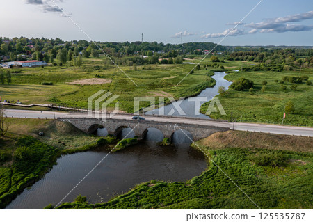 Stone Bridge Crossing River in Grassy Area 125535787