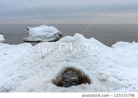 Close-up shot of the Frozen ice blocks in Baltic sea water on the shore, Kaltene, Latvia 125535796