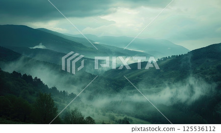 Thick morning fog rolling over a mountain valley, mystical and moody atmosphere Thick morning fog rolling over a mountain valley, mystical and moody atmosphere 125536112