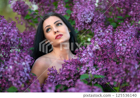 Woman among lilac blossoms. Shallow depth of feld Woman among lilac blossoms. Shallow depth of feld 125536140