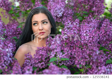 Woman among lilac blossoms. Shallow depth of feld Woman among lilac blossoms. Shallow depth of feld 125536141