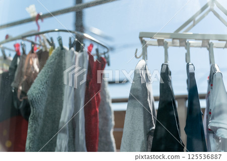 Family hanging out laundry on the balcony Family hanging out laundry on the balcony 125536887