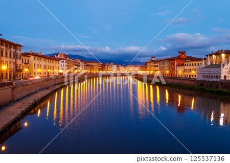 Panoramic view of the old town of Pisa and the Arno river at twilight, Italy. Night cityscape 125537136