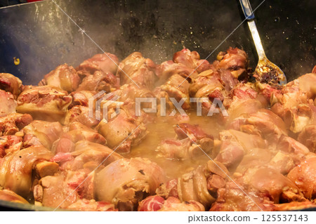 Cooking of pork knuckle (traditional german dish) in big cauldron 125537143