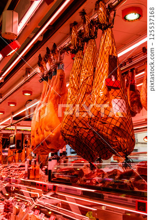 Jamon serrano ham legs hanging in a traditional spanish market Jamon serrano ham legs hanging in a traditional spanish market 125537168
