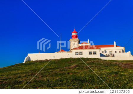 Lighthouse on the cliff at Cabo da Roca. Cabo da Roca or Cape Roca is westernmost cape of mainland Portugal, continental Europe and the Eurasian land mass Lighthouse on the cliff at Cabo da Roca. Cabo da Roca or Cape Roca is westernmost cape of mainland Portugal, continental Europe and the Eurasian land mass 125537205