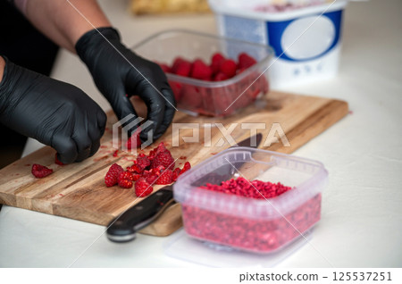 Preparing raspberries for dessert. Shallow depth of feld 125537251