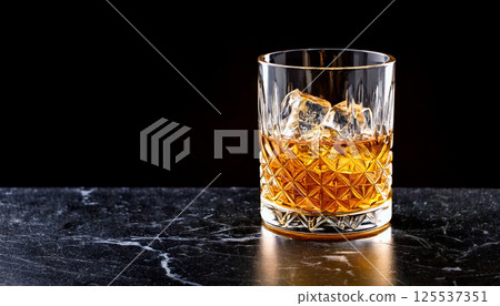 close up of premium whiskey glass with clear ice cubes on sleek black marble surface, creating sophisticated and elegant atmosphere close up of premium whiskey glass with clear ice cubes on sleek black marble surface, creating sophisticated and elegant atmosphere 125537351