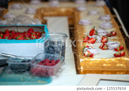 Cake decorating with berries. Shallow depth of feld 125537639