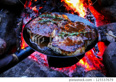 Cooking meat in a bonfire frying pan Cooking meat in a bonfire frying pan 125537679