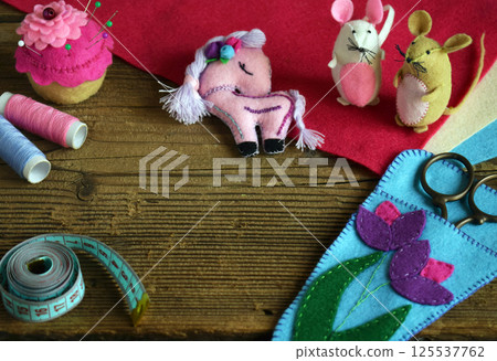 Making case for scissors decored with pink and purple flower. Sewing from felt with your own hands. DIY concept for children. Handmade crafts. 125537762