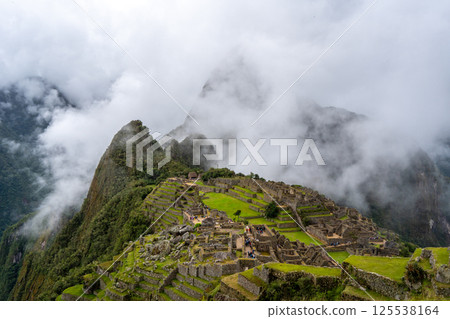 Panoramic view of Machu Picchu ruins surrounded by misty mountains, Peru 125538164