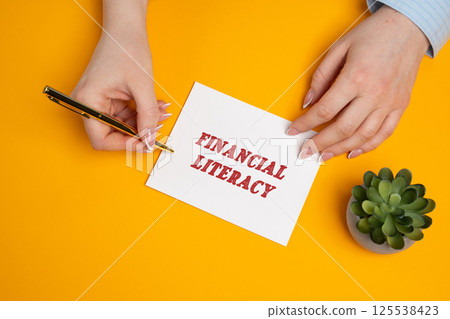 Financial literacy concept. Ability to understand and apply various financial skills, including personal financial management, budgeting, and investing. A woman writes a message in notes 125538423