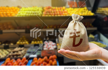 Turkish lira money bag on the background of a grocery store counter with fresh organic vegetables and fruits. Concept of cost of goods and food products. Grocery set. Import and export 125538439