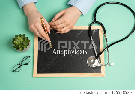 Anaphylaxis concept. Serious, potentially fatal allergic reaction and medical emergency that is rapid in onset and requires immediate medical attention. Woman writes on the board near the stethoscope Anaphylaxis concept. Serious, potentially fatal allergic reaction and medical emergency that is rapid in onset and requires immediate medical attention. Woman writes on the board near the stethoscope 125538580