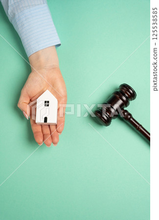 Judge's gavel near miniature wooden house. Real estate court decisions. Property inheritance litigation. Establishment of ownership. 125538585