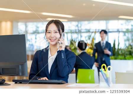 A young businesswoman working in an office. Photo courtesy of Denpa Gakuen, Tokyo Electronics College. 125539304