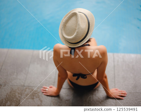 Young woman relaxing by the pool at a Kuala Lumpur hotel 125539491