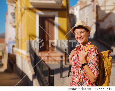 Woman strolls through colorful streets of Spanish coastal town 125539619
