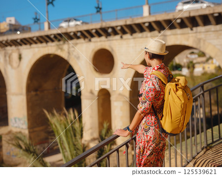 Woman strolls through colorful streets of Spanish coastal town 125539621