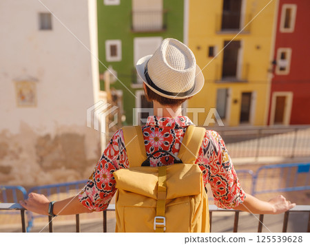 Woman strolls through colorful streets of Spanish coastal town Woman strolls through colorful streets of Spanish coastal town 125539628