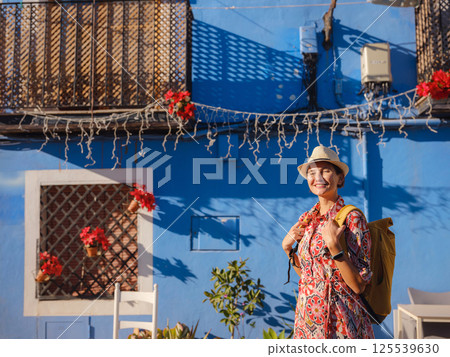 Woman strolls through colorful streets of Spanish coastal town 125539630