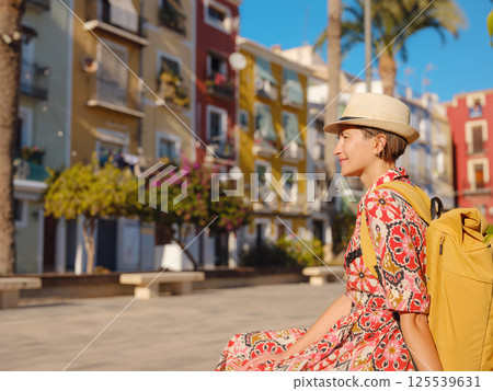 Woman strolls through colorful streets of Spanish coastal town 125539631