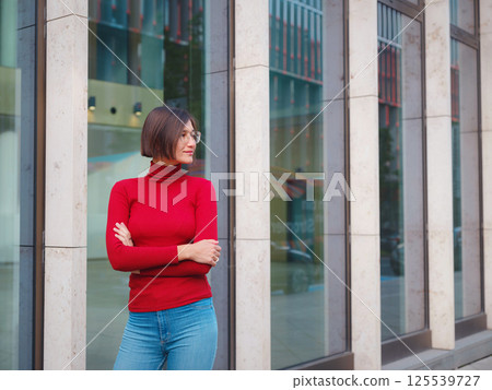 Woman in glasses stands in center of Frankfurt, 125539727