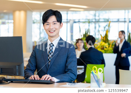 Young businessmen working in an office. Photo courtesy of Denpa Gakuen, Tokyo Electronics College. 125539947