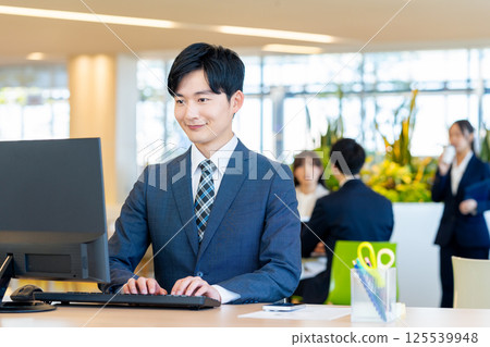 Young businessmen working in an office. Photo courtesy of Denpa Gakuen, Tokyo Electronics College. 125539948