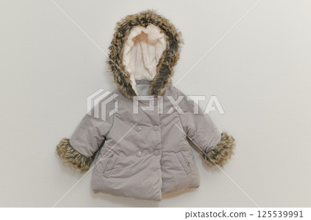 Grey-lilac colored winter jacket hanging on hanger on white background Grey-lilac colored winter jacket hanging on hanger on white background 125539991