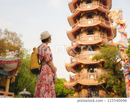 Woman Exploring Colorful Streets Near Buddhist Temples in Bangkok 125540096