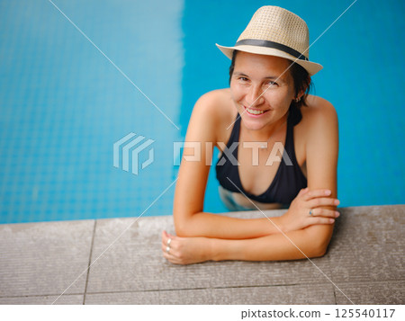 Young woman relaxing by the pool at a Kuala Lumpur hotel 125540117