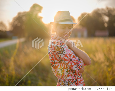 boho chic woman in a floral dress in European countryside boho chic woman in a floral dress in European countryside 125540142