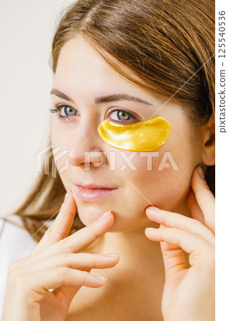 Woman with gold patches under eyes Woman with gold patches under eyes 125540536