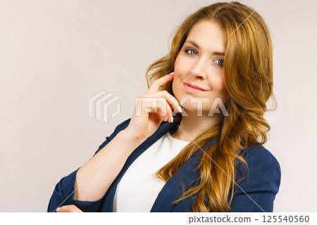 Business woman in suit looking at camera Business woman in suit looking at camera 125540560