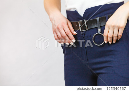 Woman wearing high waist trouser with belt 125540567