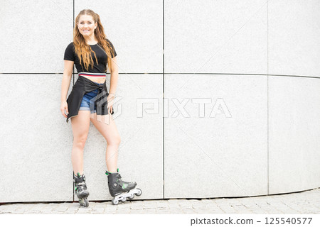 Young woman riding roller skates 125540577