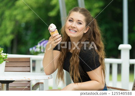 Young woman eating ice cream Young woman eating ice cream 125540588